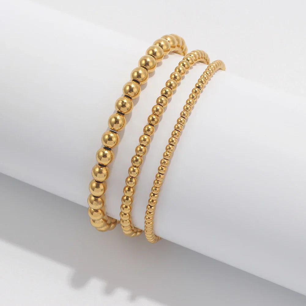 Set aus goldfarbenen Kugelarmbändern
