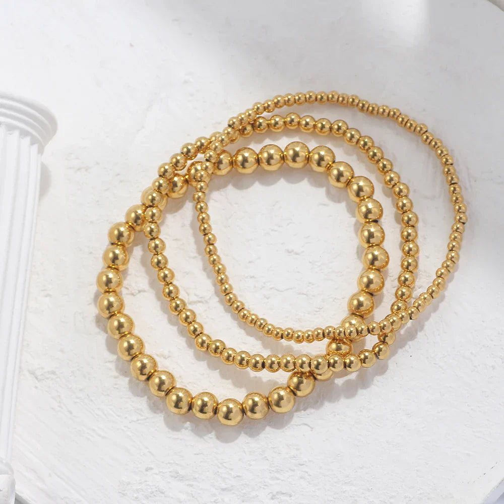 Set aus goldfarbenen Kugelarmbändern